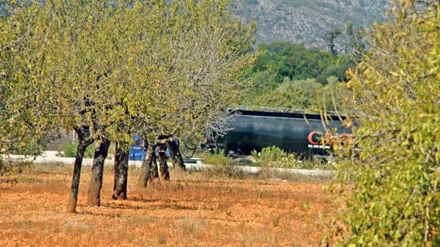 Imagen de un camión de gran tonelaje circulando ante los terrenos que se cederán al Consell.