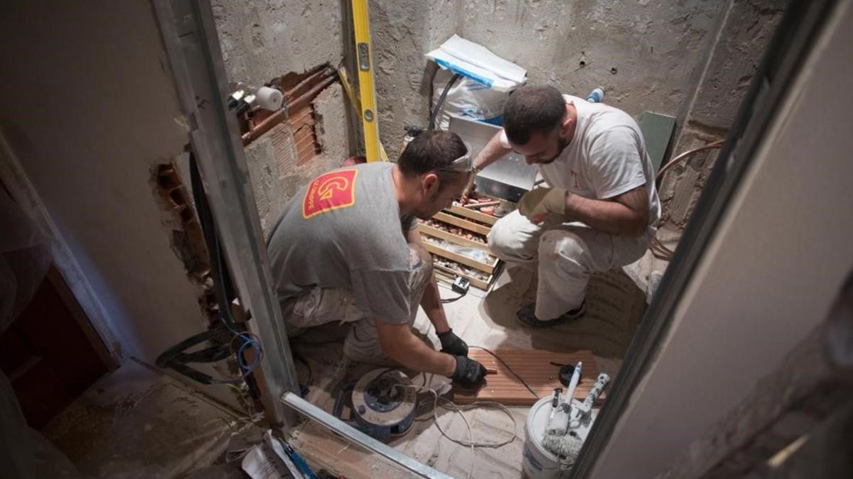 Dos trabajadores reformando una vivienda.