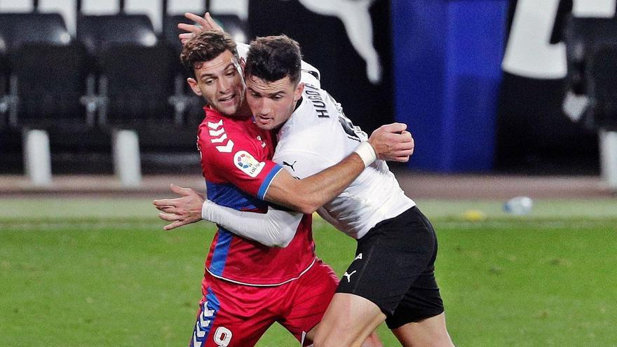 Lucas Boyé lucha por un balón con el central del Valencia Hugo Guillamón durante el partido de ayer en Mestalla. | JUAN CARLOS CÁREDENAS/EFE