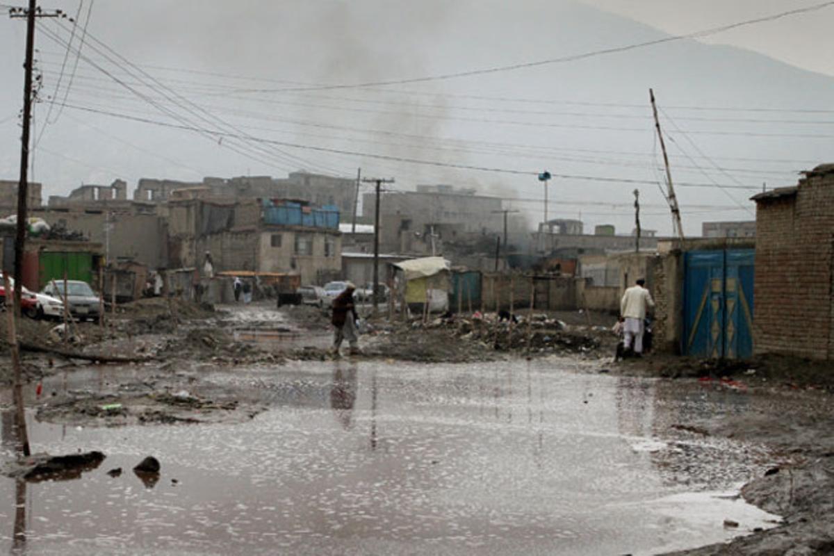 Un home camina per un carrer inundat a Kabul (Afganistan).