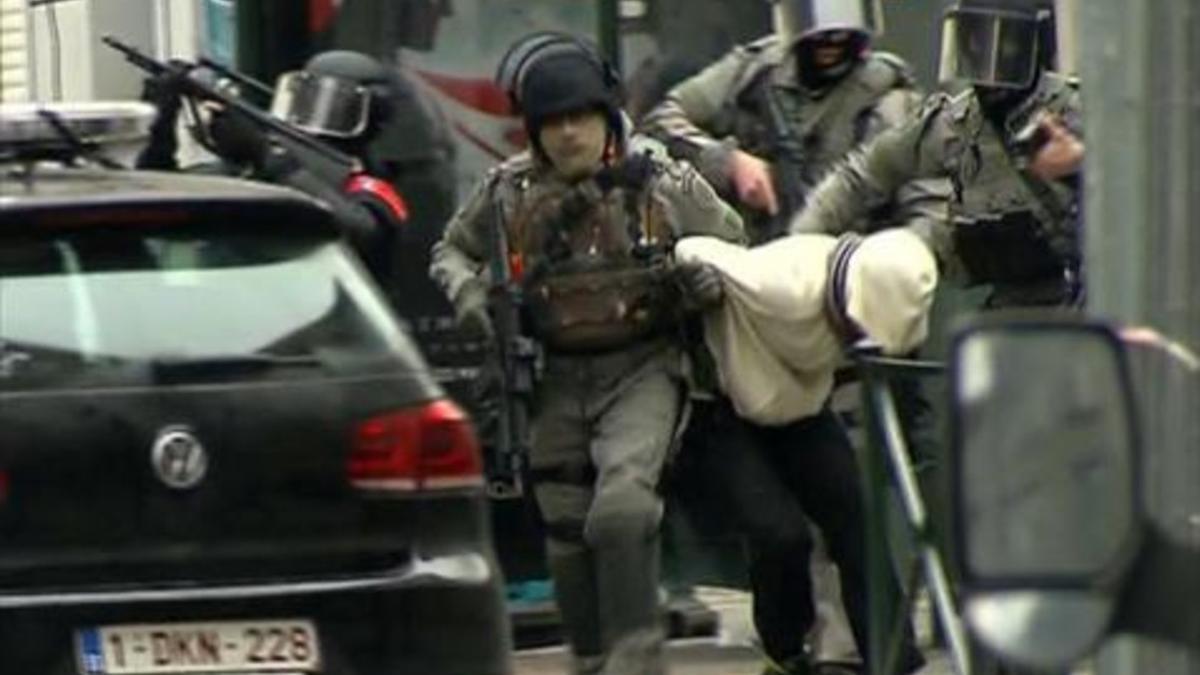 Un sospechoso es conducido por la policía en el barrio de Molenbeek (Bruselas), ayer.