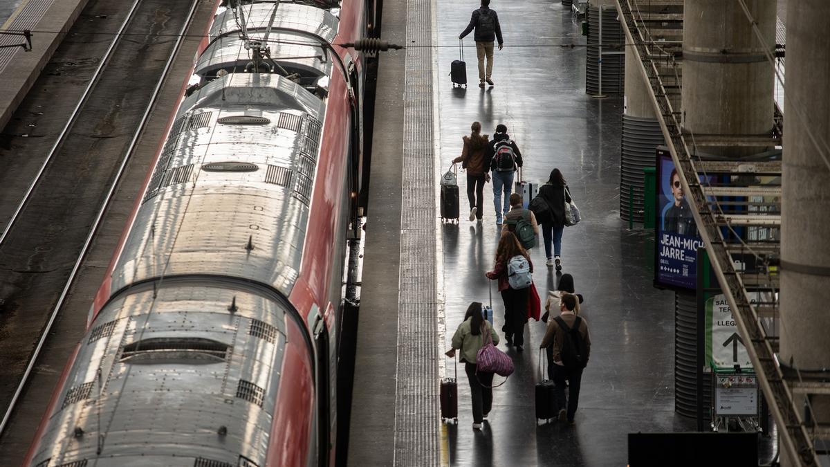 Varios pasajeros abordan este miércoles un tren en la estación Puerta de Atocha, de Madrid.