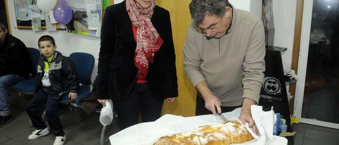 Dos de los voluntarios cortan la rosca. // Noé Parga