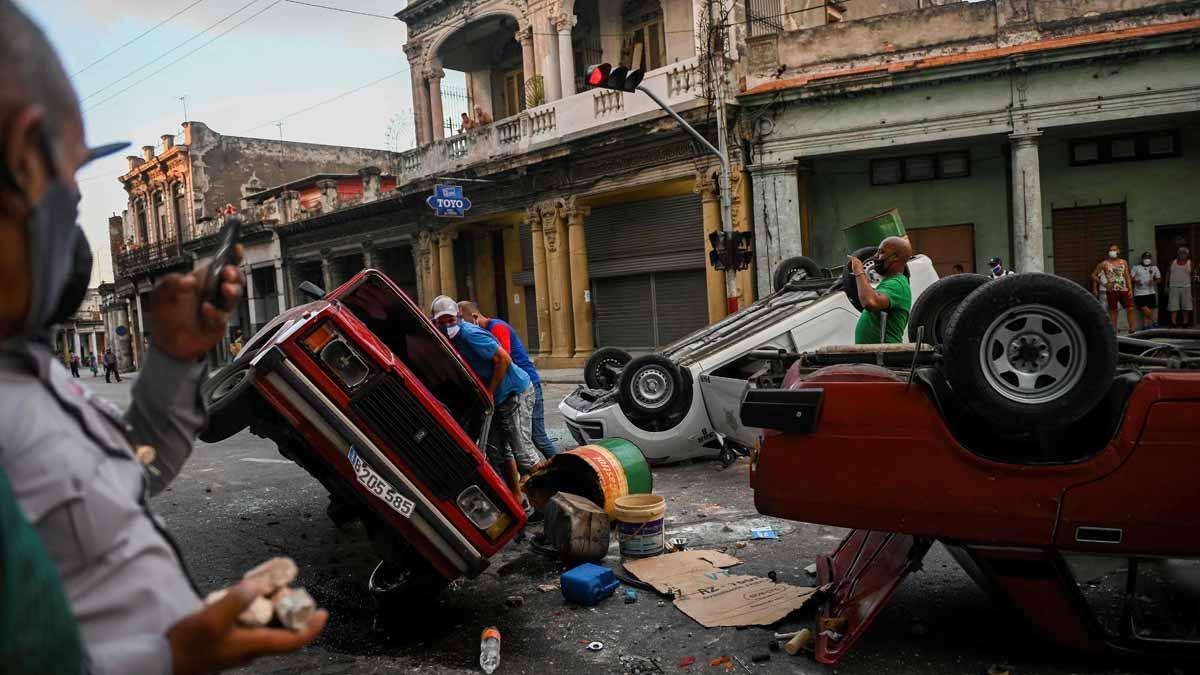 Coches de policía destrozados en las protestas ciudadanas en La Habana.