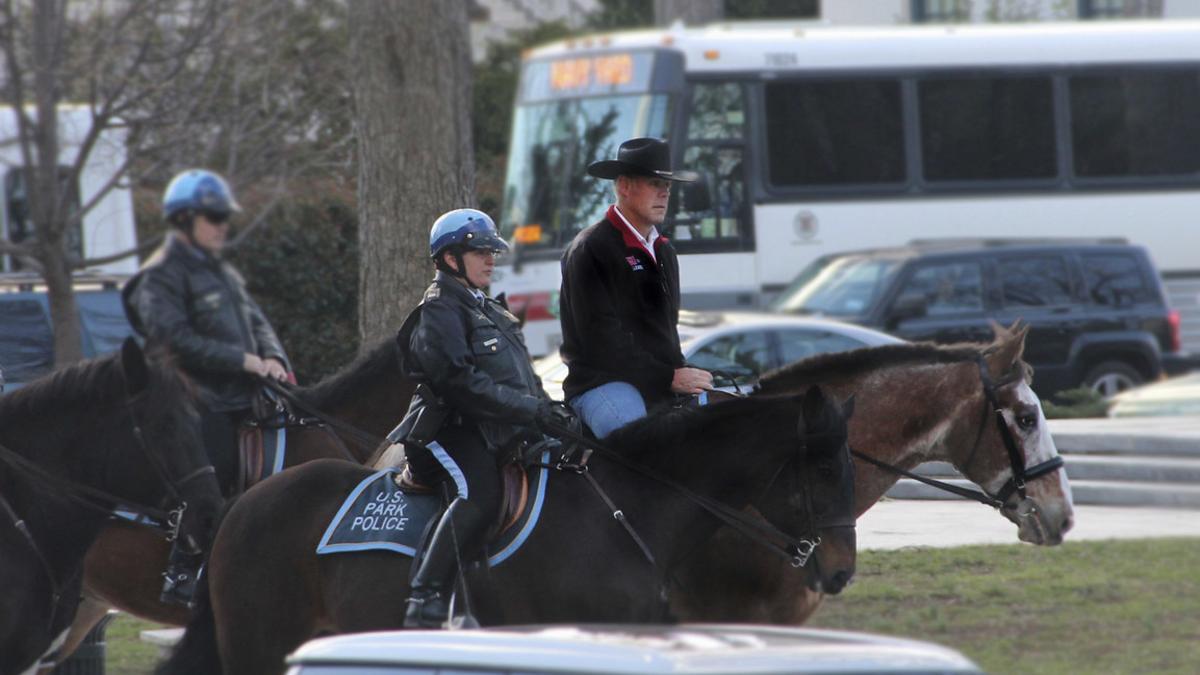 Ryan Zinke, a lomos de un cabllo y con sombrero vaquero, dirigiéndose a la oficina, ayer.