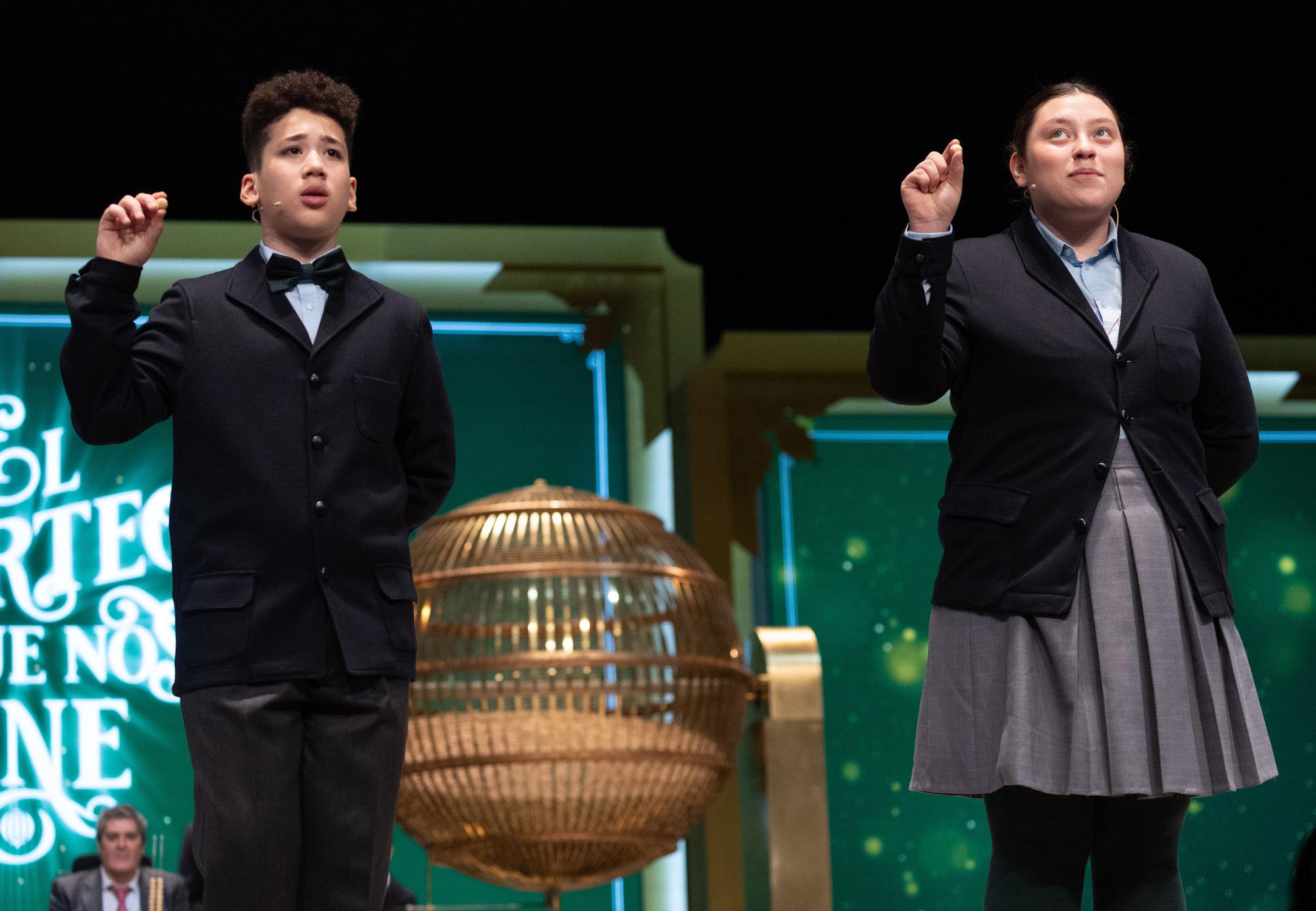 Kiara Román Benítez y Antoni Ramírez Bonito cantan uno de los quintos premios, el número 57421, durante el Sorteo Extraordinario de la Lotería de Navidad 2023 en el Teatro Real de Madrid, a 22 de diciembre de 2023, en Madrid (España). El sorteo se celebra