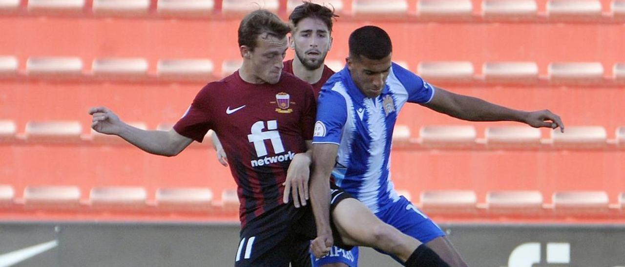 Mounir controla el esférico ante dos rivales en el partido en Elda.