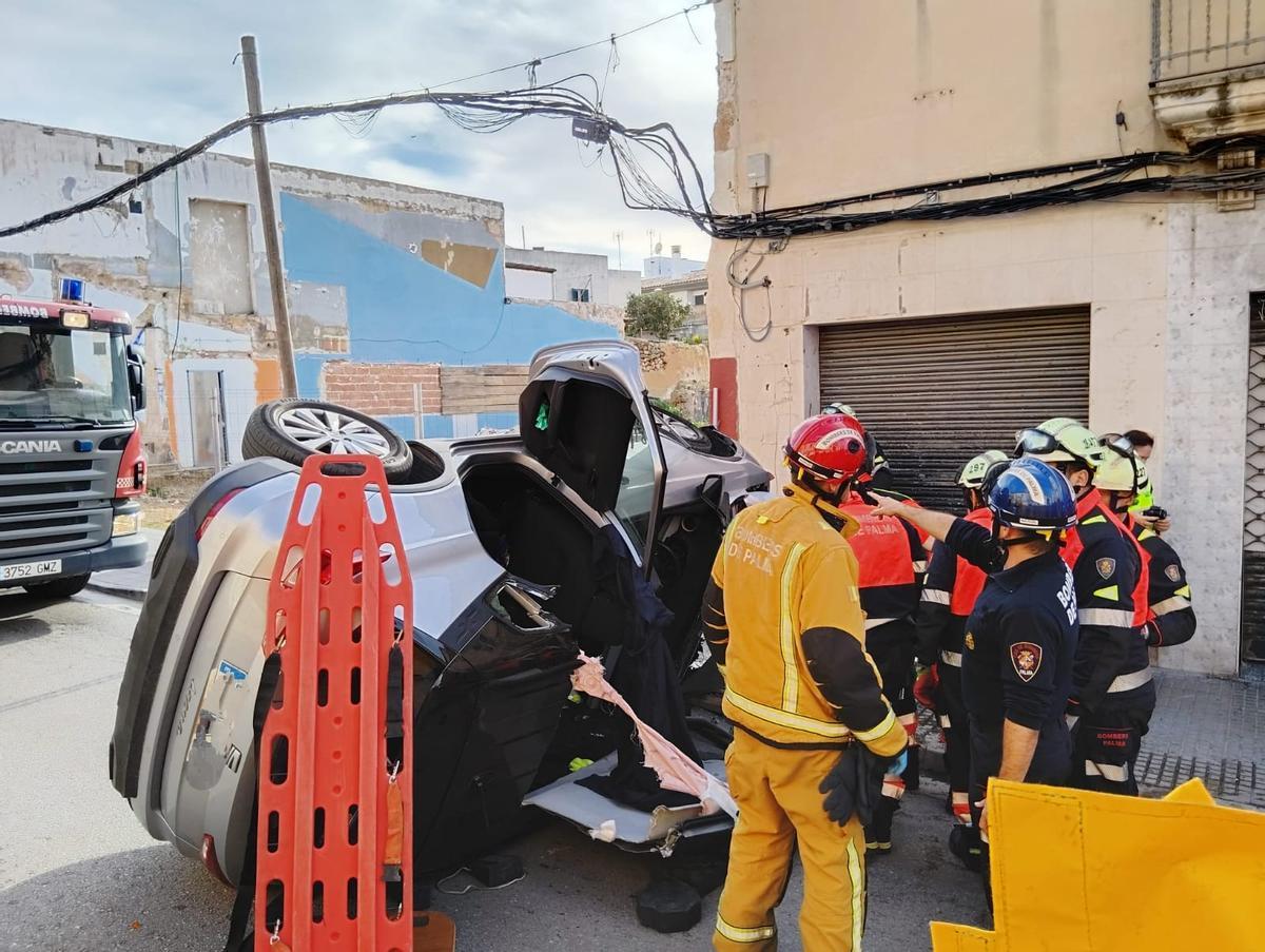 Los Bombers de Palma, junto al vehículo siniestrado tras rescatar a los dos ancianos.
