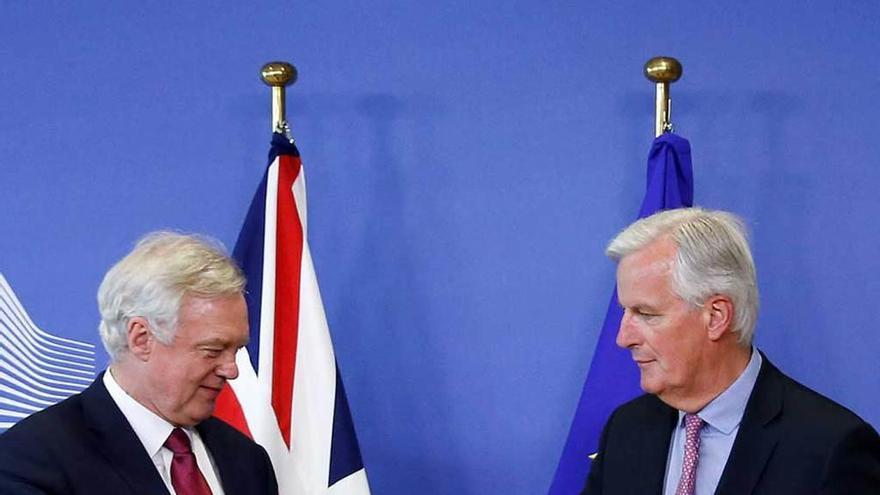 El comunitario Barnier, derecha, estrecha la mano de Davis.
