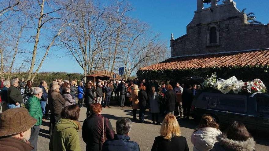 La familia espera la llegada del féretro rodeada de vecinos, frente a la iglesia del Carmen.