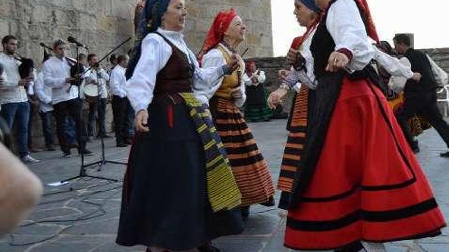 Bailes y cantos en la plaza del Castillo de Puebla y, la derecha, participantes en la &quot;Noche Romántica&quot; en la fortaleza de la villa.