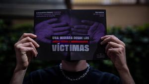 Un joven sostiene el cartel de promoción del reciente congreso sobre violencia vicaria en Barcelona.