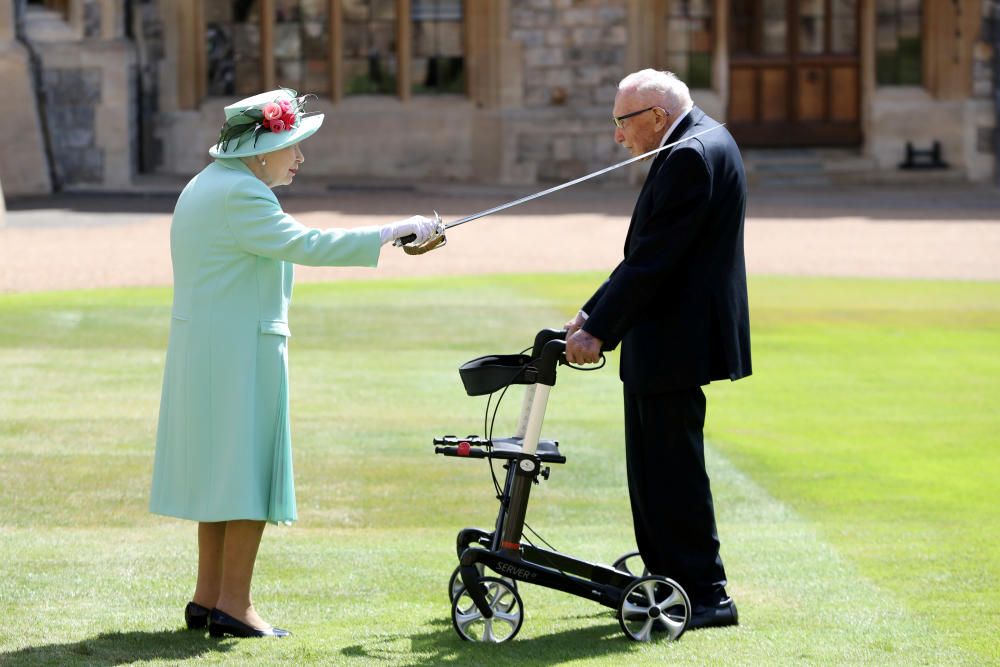 La Reina de Gran Bretaña otroga el rango de Caballero al capitán Tom Moore en Windsor. Foto: Reuters