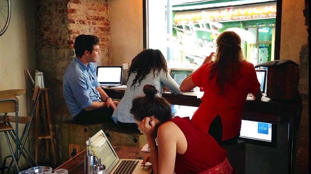 Varios jóvenes, con sus portátiles, en una cafetería de Madrid.