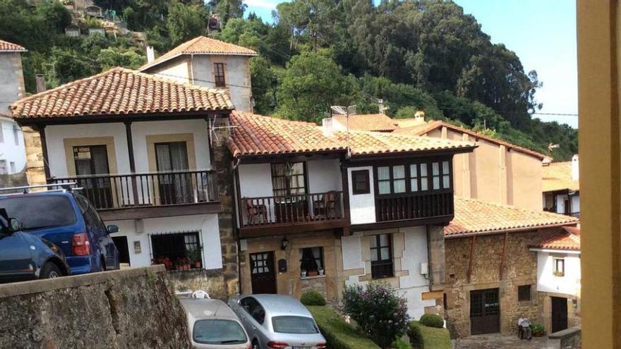 La plaza del Cañu de Lastres, con varios coches aparcados.