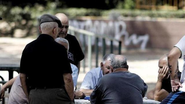 Diversos pensionistes juguen a dòmino en un parc de Madrid.