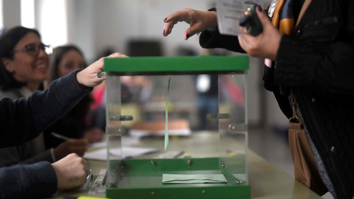 Una persona deposita su voto en un colegio electoral.