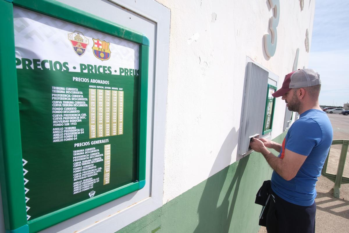 Un aficionado comprando su localidad, con la lista de precios al lado