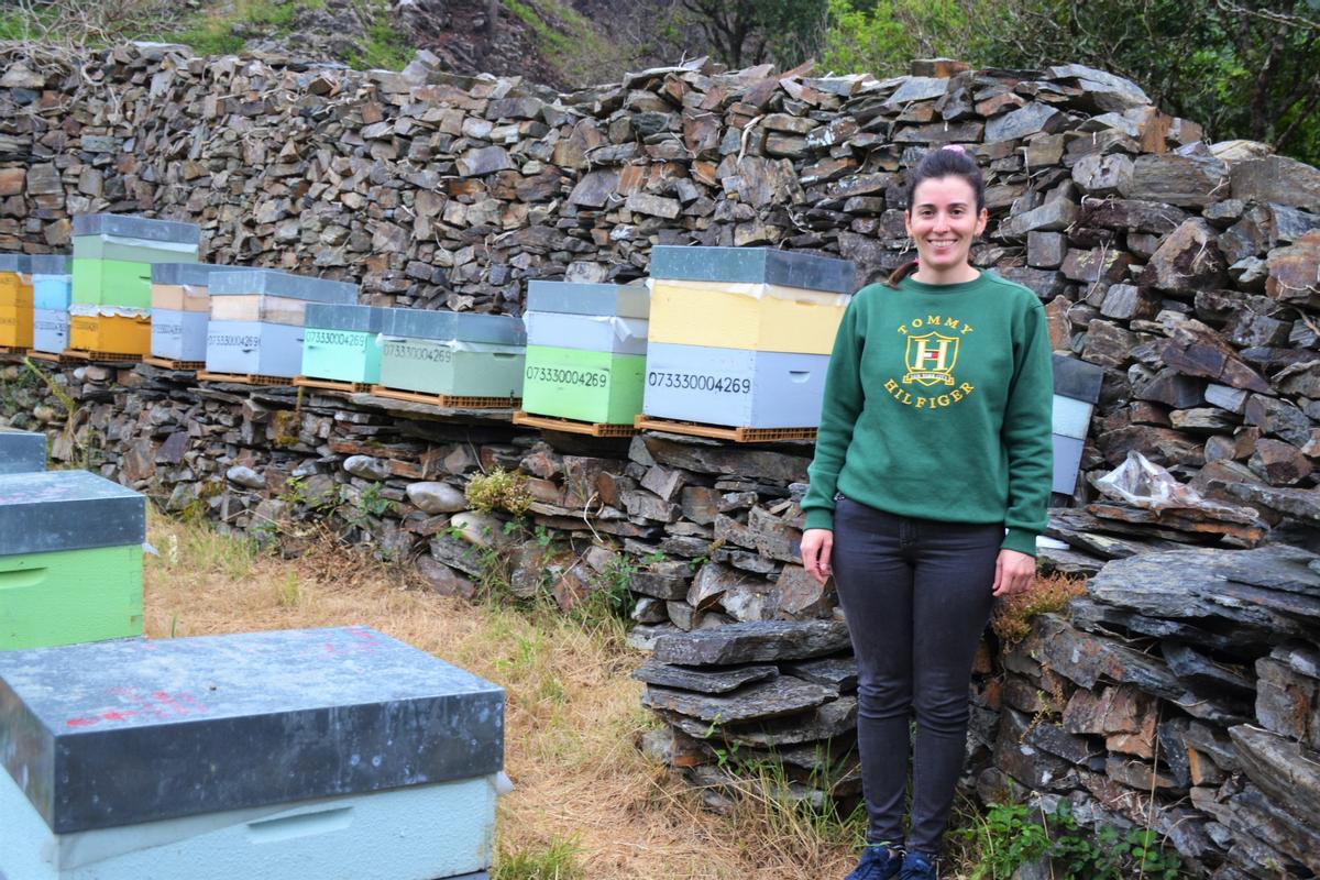 Nuria Gallo junto algunas de las colmenas que tienen en el cortín de Villar de Navelgas.