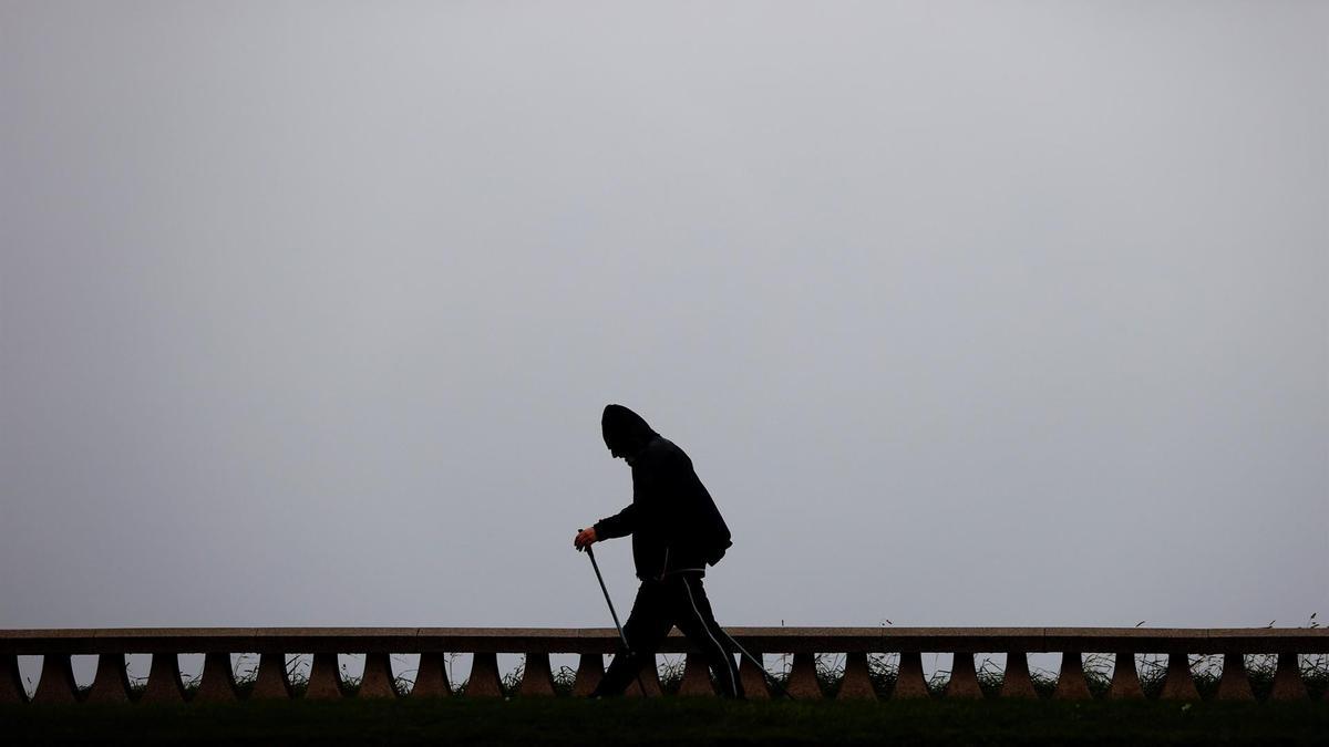 Un hombre camina bajo la lluvia