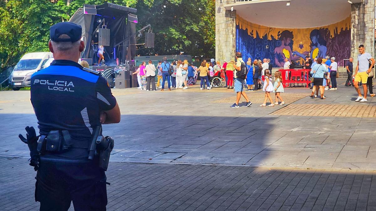 Un policía local vigila durante el principio del último concierto de las fiestas de San Xuan, el del dúo Reflejos en el parque Jovellanos. | A. Velasco