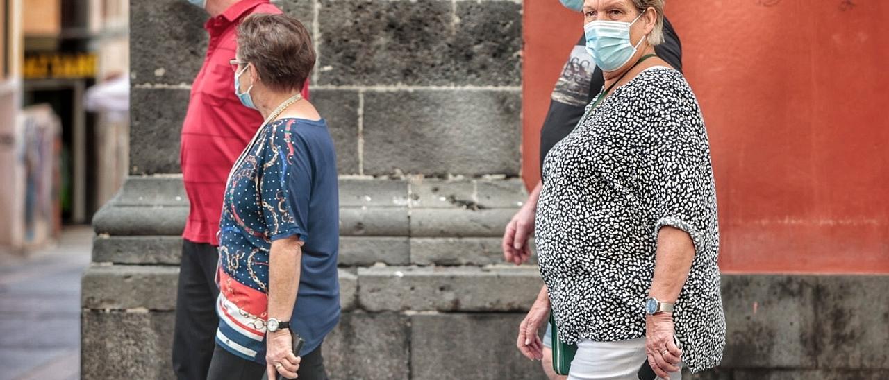 Varias personas pasean en Santa Cruz de Tenerife con mascarilla para evitar contagios de coronavirus.