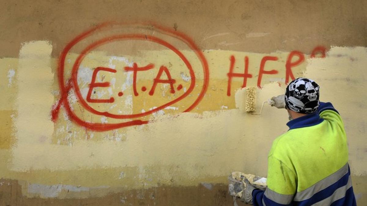 Un empleado municipal de Gernika (Vizcaya) borra una pintada de apoyo a ETA el 21 de octubre del 2011, un día después de que la banda anunciara el cese de la violencia.