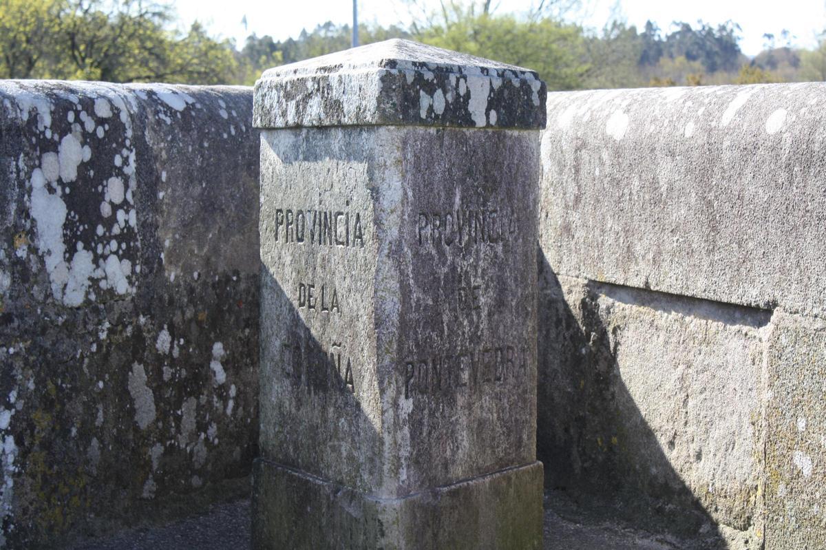 El marcador que divide las dos provincias que une el puente, A Coruña y Pontevedra, mirando hacia el este