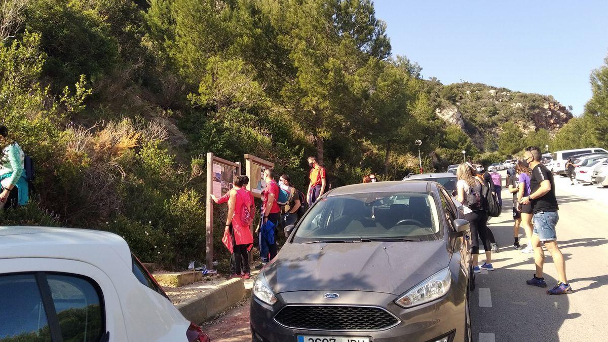 Excursionistas en el inicio de la ruta desde el aparcamiento de la cala del Moraig.