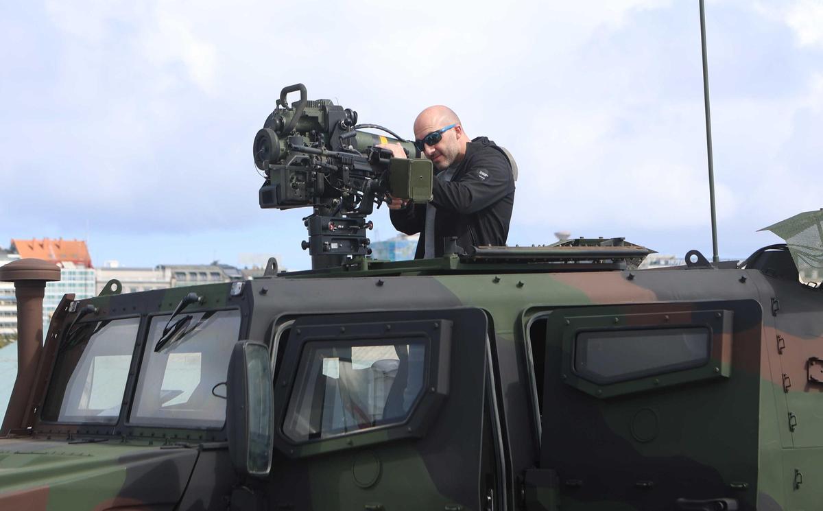 Un vistante subido a uno de los vehículos militares expuesto en el buque 'Castilla'