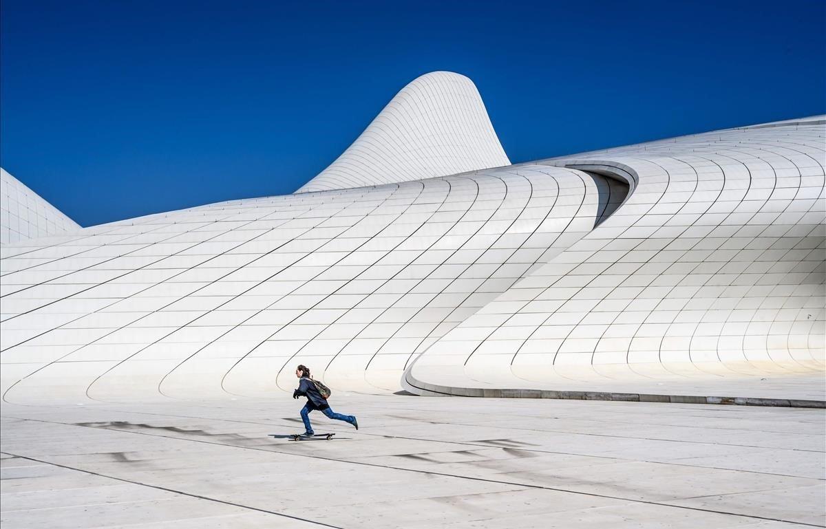 Un niño patina frente al Centro Heydar Aliyev en Baku, edificio diseñado por la arquitecta iraquí-británica, Zaha Hadid. 