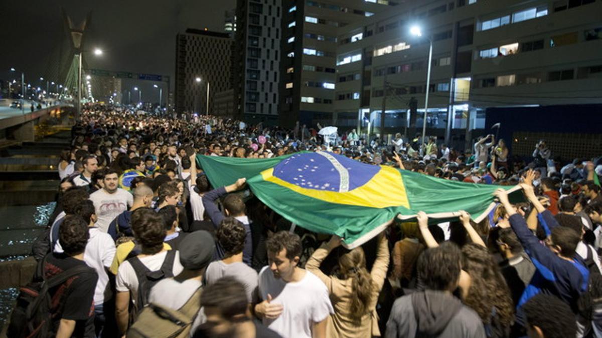 Estudiantes levantan una bandera de Brasil durante las protestas en Sao Paulo.
