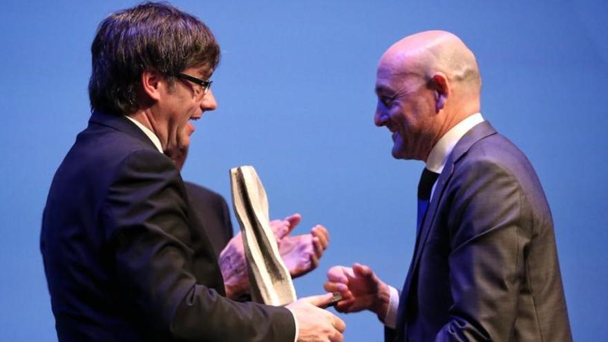 El físic berguedà rep el premi de mans del Carles Puigdemont.