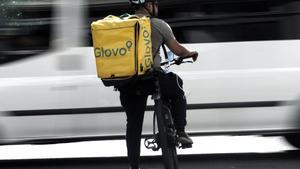 Un rider de la empresa de reparto de comida a domicilio Glovo, pasea por una calle de Madrid con su bicicleta en 2019.