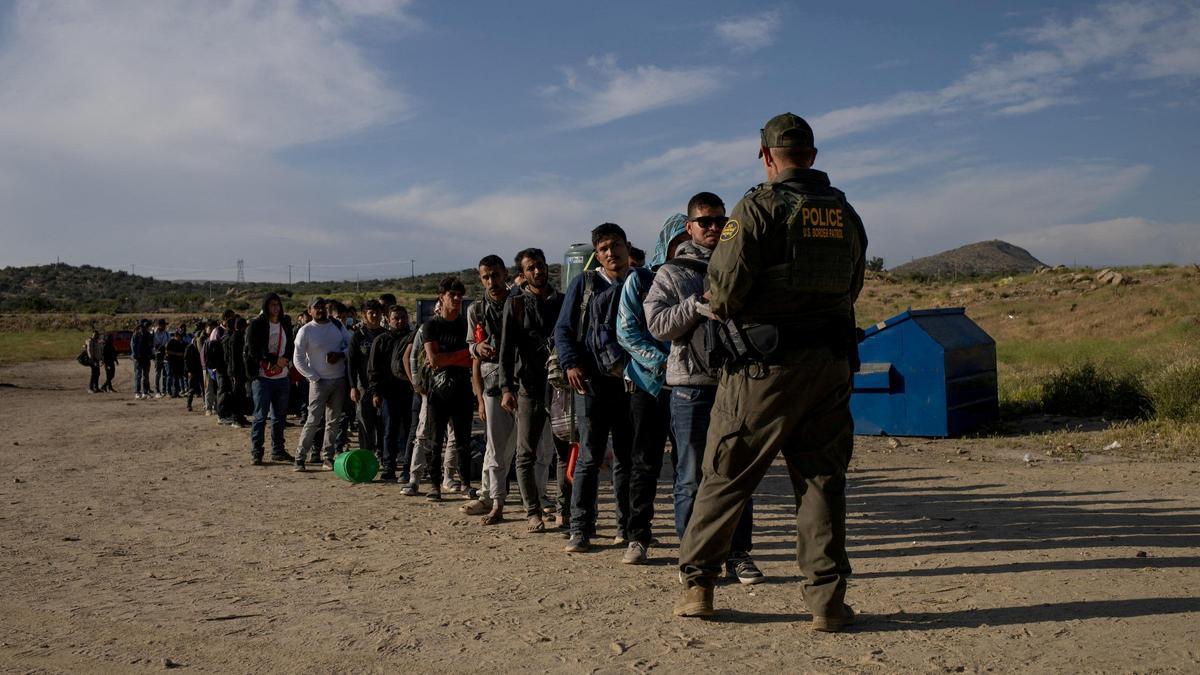 Un grupo de inmigrantes se entregan a las autoridades de EEUU tras cruzar la frontera con México.