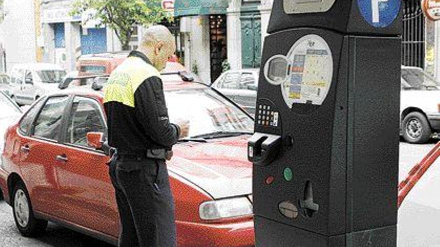 Un vigilante, controlando los vehículos estacionados en la calle Oporto, ayer. / ricardo grobas