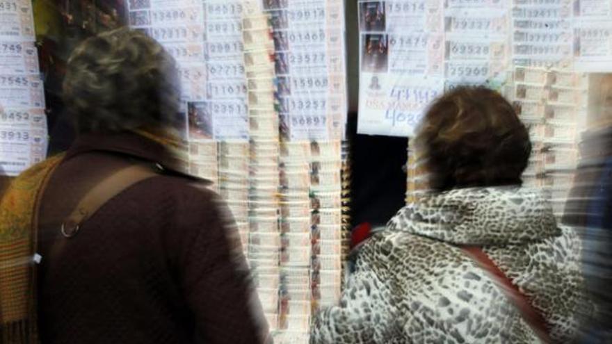 Unas mujeres compran Lotería de Navidad.