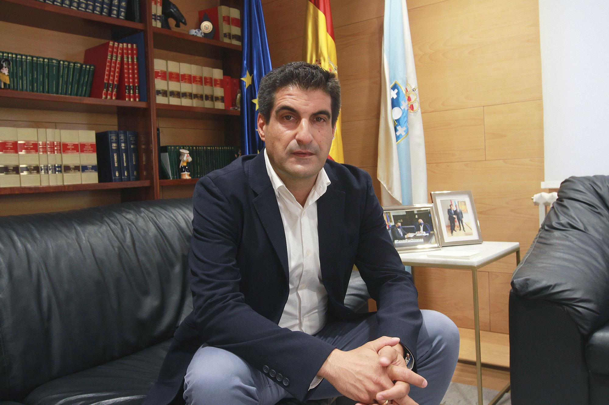 Gabriel Alén, en su despacho, con dos fotos en las que acompaña a Feijóo y Baltar. // IÑAKI OSORIO
