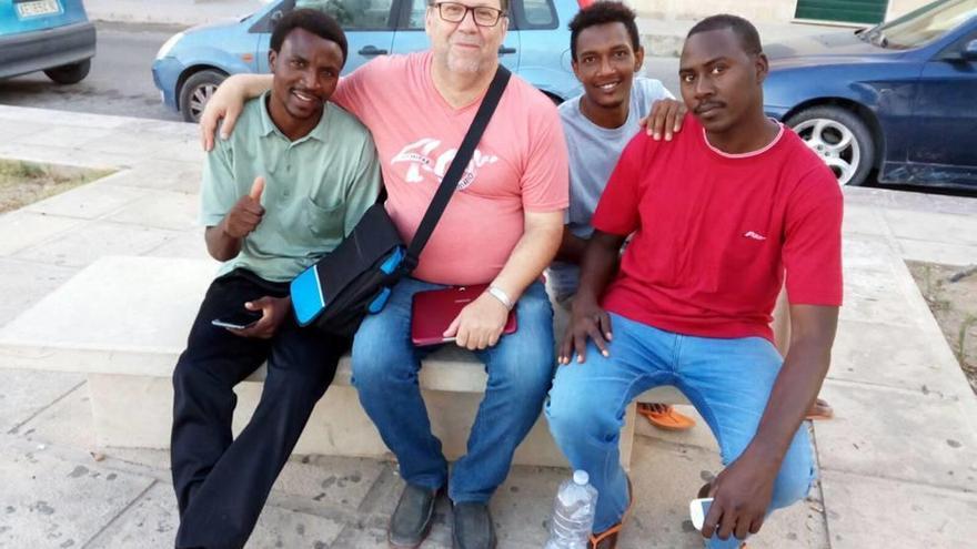 El cura Joaquín, en el centro, con algunos de los refugiados con los que convive en Lampedusa. L. O.