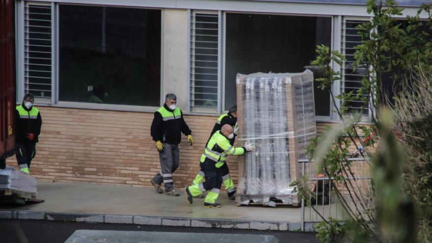 Operarios introduciendo las camas en el interior del centro