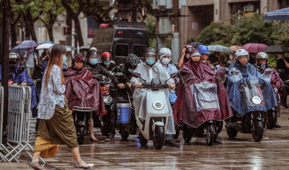 -FOTODELDIA- Shanghái (China), 14/09/2022.- La gente monta scooters durante un día lluvioso cuando se espera que el tifón Muifa toque tierra, en Shanghái, China, el 14 de septiembre de 2022. Las autoridades chinas emitieron una alerta roja en la provincia oriental de Zhejiang donde se esperaba que el tifón Muifa tocara tierra en la costa este. La ciudad de Shanghái suspendió todos los vuelos desde los aeropuertos de Pudong y Hongqiao, detuvo las operaciones portuarias, cerró las estaciones de metro y limitó la velocidad de los trenes terrestres. Ningbo, Taizhou y la ciudad de Zhoushan recibieron la orden de suspender las clases por el día, ya que se espera que el tifón se mueva hacia el noroeste después de tocar tierra. EFE/ALEX PLAVEVSKI