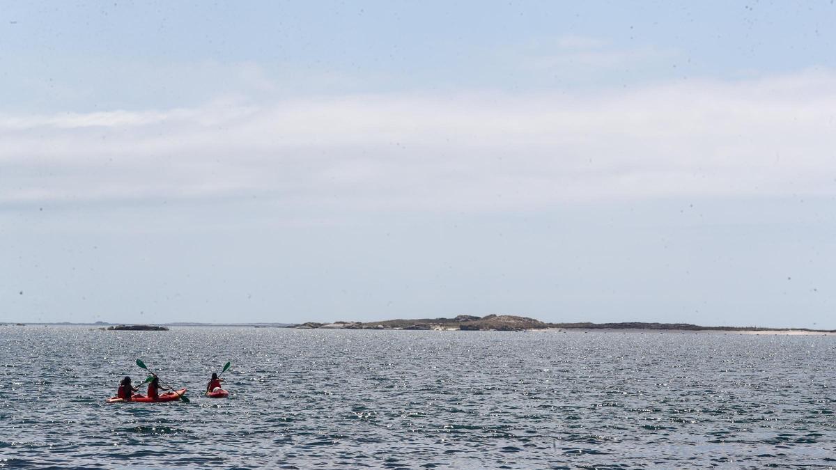 Un grupo de kayaks reman hacia el Areoso.