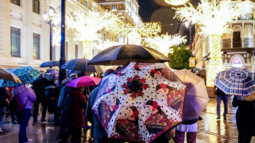 Numeroso público con paraguas en la Avenida de la Constitución contemplando la iluminación navideña de la ciudad, a 16 de diciembre de 2025, en Sevilla (España).