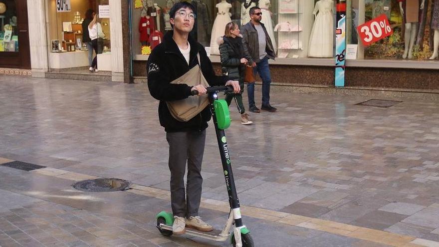 Un usuario en patinete por el centro de la capital.