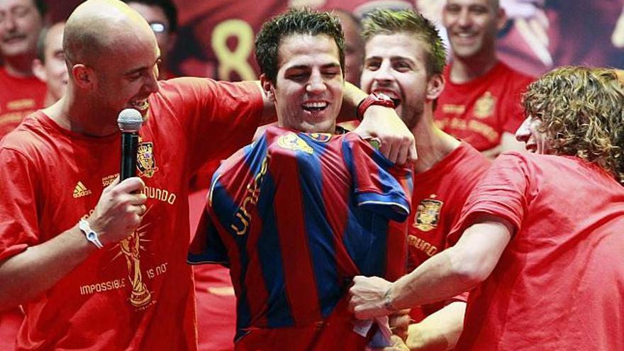 Piqué y Puyol ponen una camiseta del FC Barcelona a Cesc Fábregas en presencia de Pepe Reina durante la celebración en Puente del Rey.