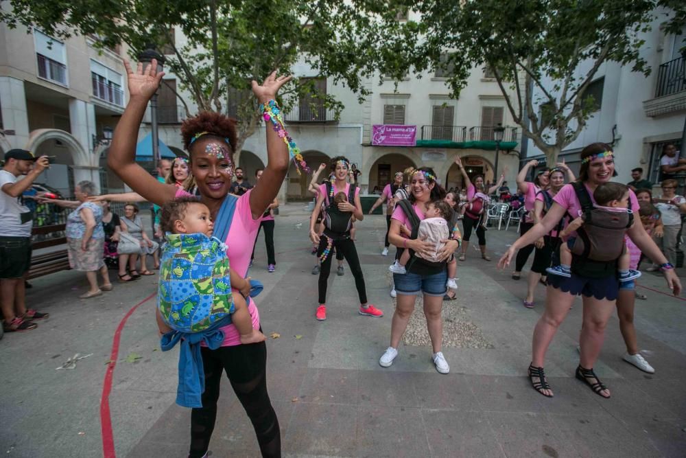 Un grupo de madres representa la canción central del musical «Mamma Mia» en la plaza de El Raval porteando a sus bebés