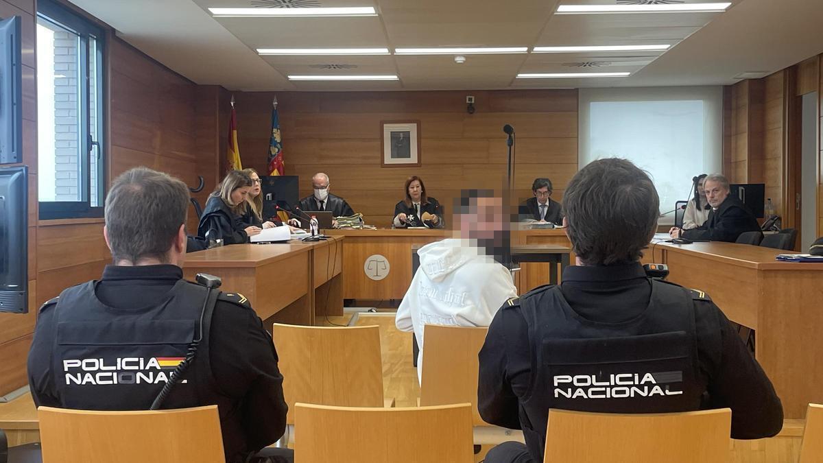 Imagen del procesado, sentado ayer en el banquillo y custodiado por dos policías nacionales.