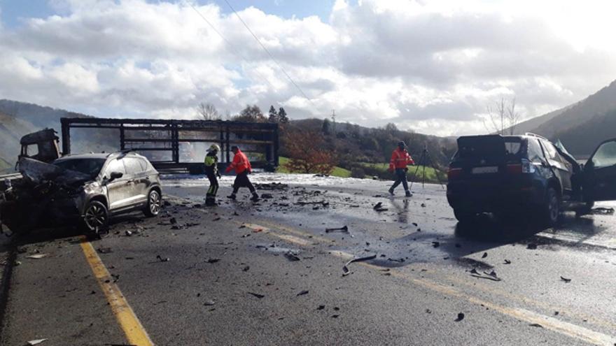 El camión incendiado, al fondo, y los dos turismos siniestrados