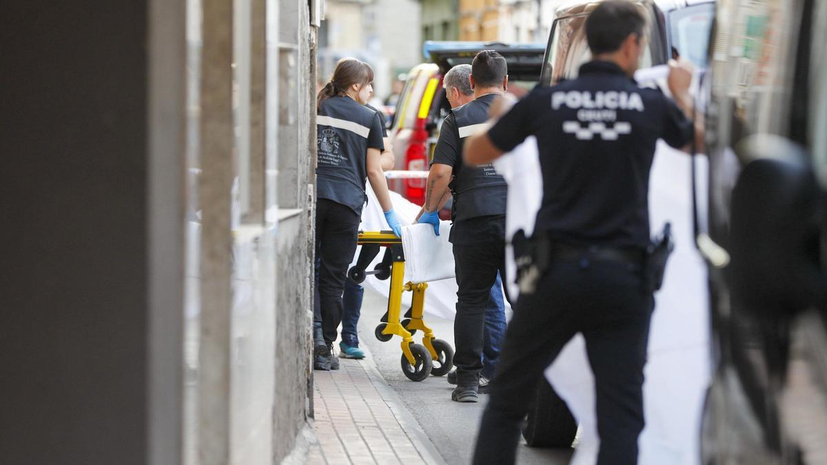 Levantamiento de uno de los tres cadáveres encontrados este sábado por la tarde en una vivienda de Ceutí.