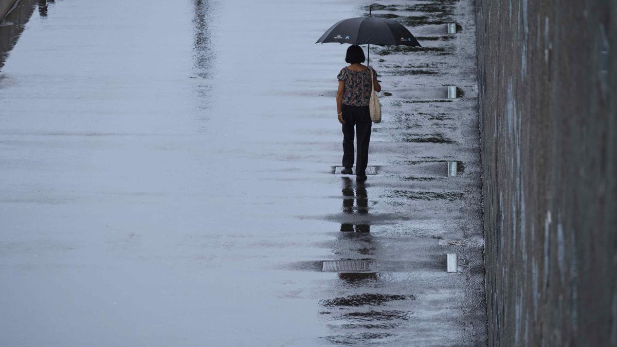 Una mujer camina bajo la lluvia en Santa Cruz de Tenerife.